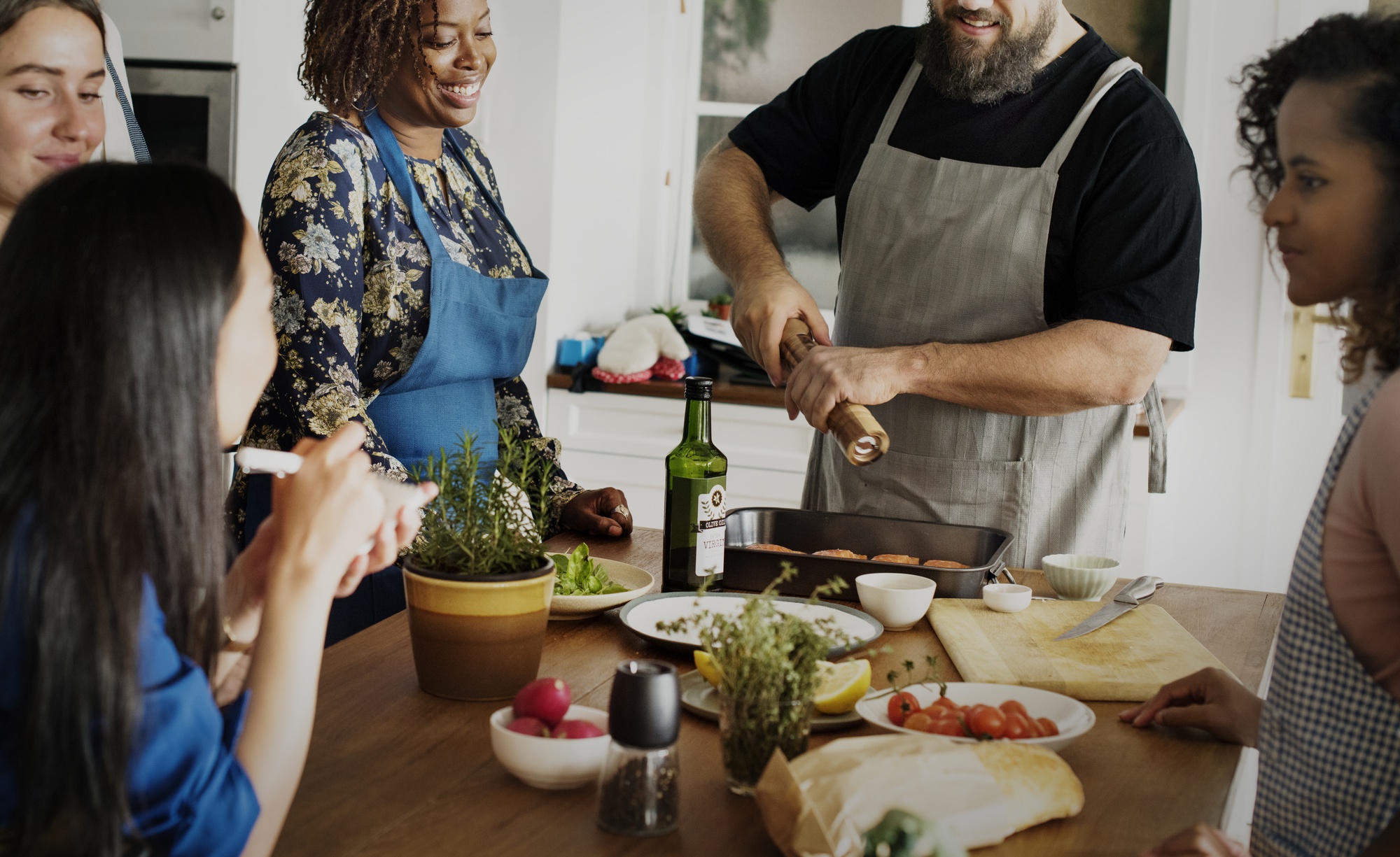 Group cooking around a large wooden table